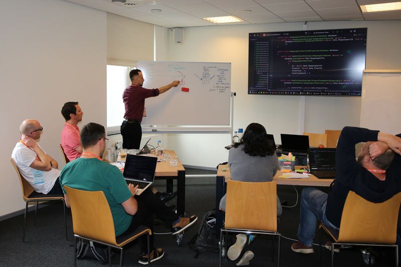 Participants work through a software model with the trainer at a whiteboard.